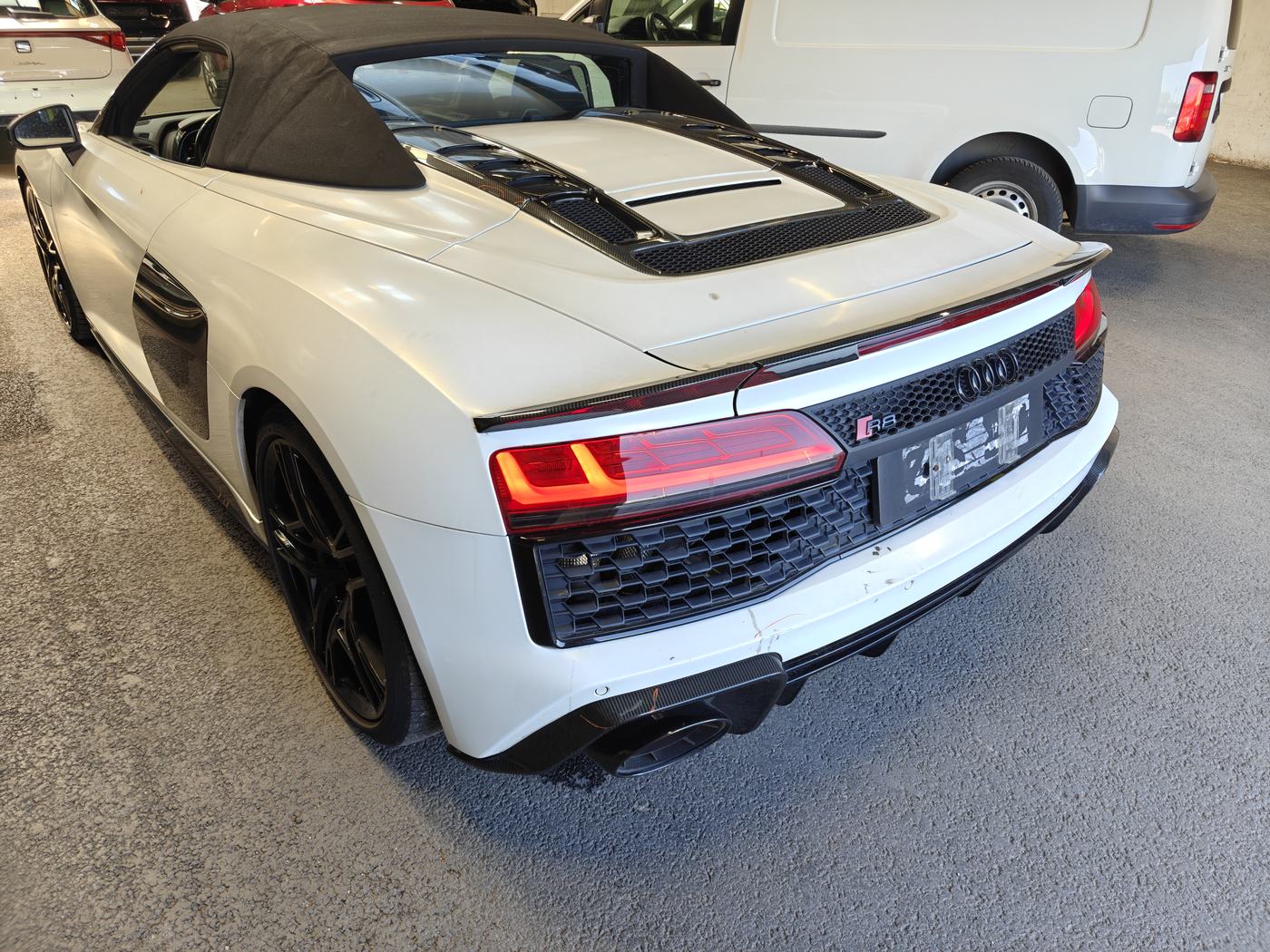 Weißer Audi R8 Spyder von schräg hinten in einer Halle