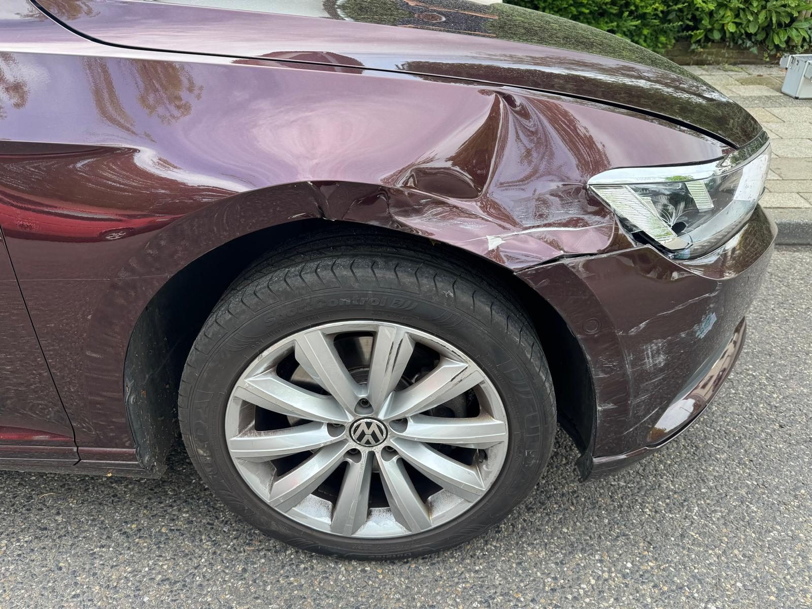 Dunkelroter VW mit eingedrücktem Kotflügel und verkratztem Stoßfänger vorne rechts